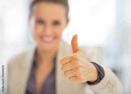 Closeup on smiling business woman showing thumbs up