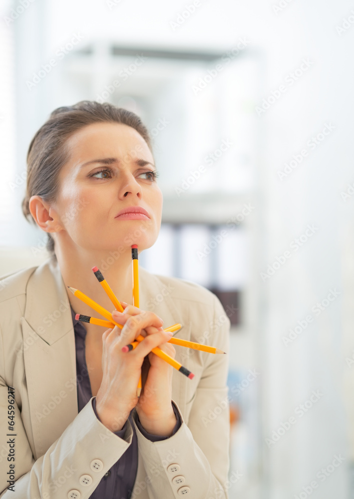 Portrait of thoughtful business woman holding pencils Portrait of thoughtful business woman holding pencils