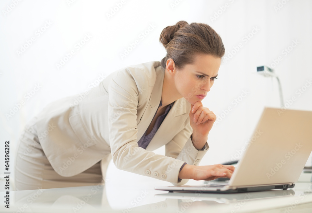 Business woman working on laptop in office Business woman working on laptop in office