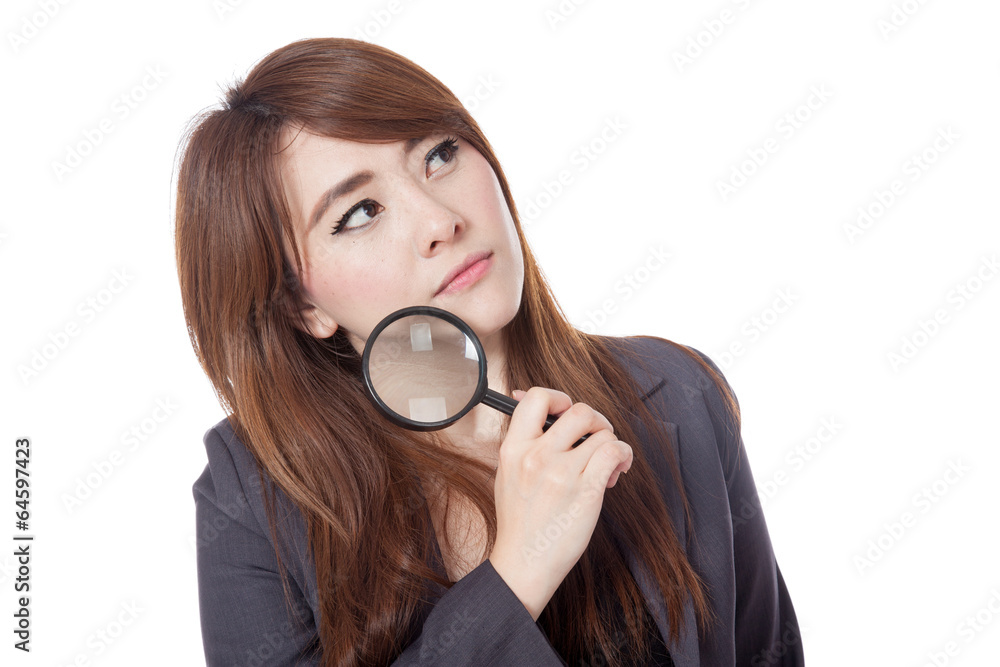 Asian businesswoman is thinking with magnifying glass looking u Asian businesswoman is thinking with magnifying glass looking u