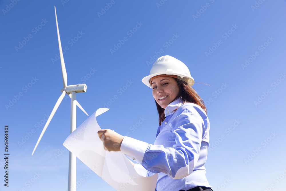 Female engineer holding a blueprints at wind farm Female engineer holding a blueprints at wind farm