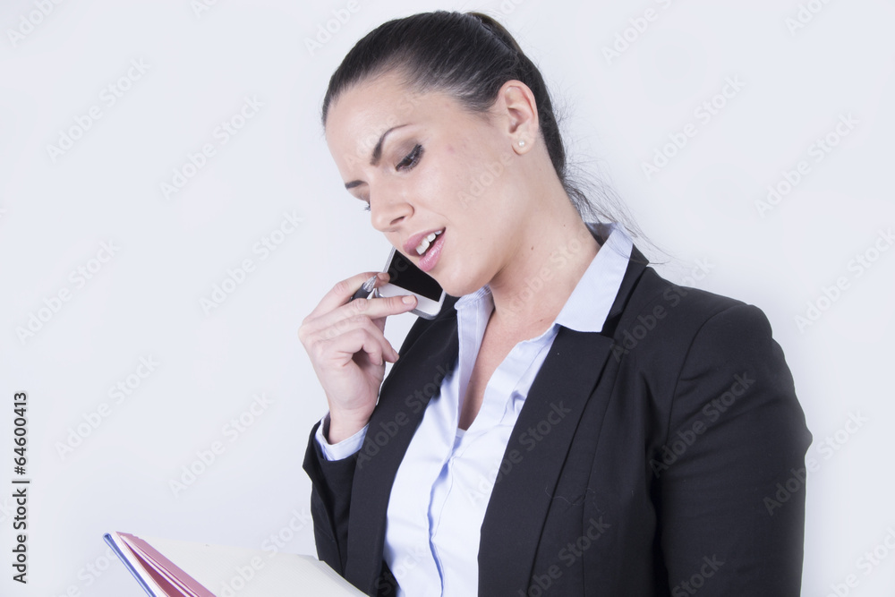 Beautiful business woman using her smartphone + notebook Beautiful business woman using her smartphone + notebook