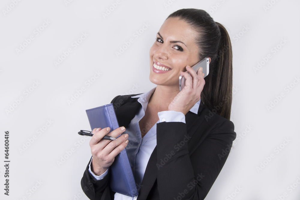 Smiling business woman making a call - smartphone - notebook Smiling business woman making a call - smartphone - notebook