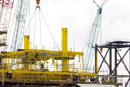 Dock workers constructing an (offshore) oil platform