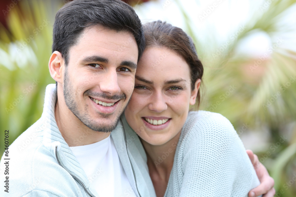 Couple embracing each other in front of house Couple embracing each other in front of house