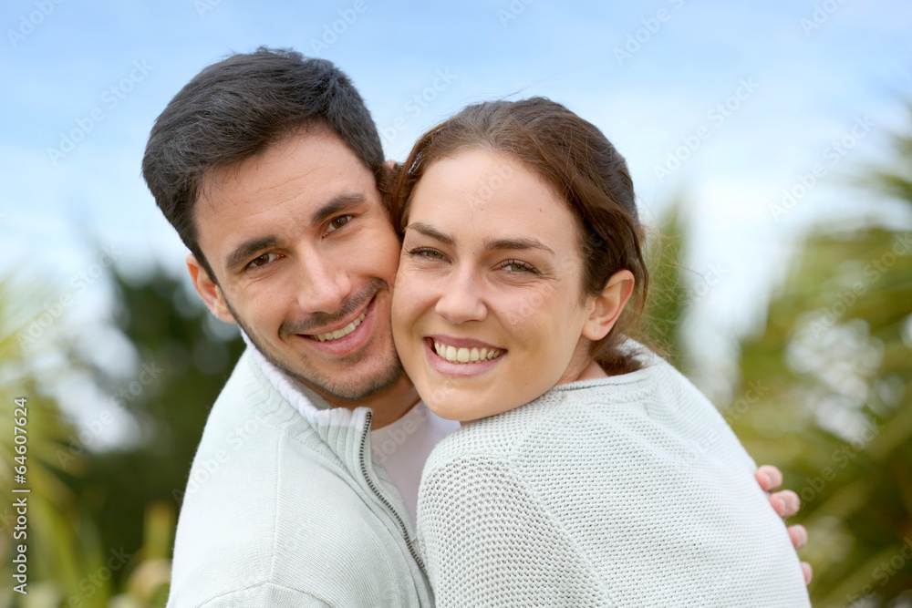 Couple embracing each other in front of house Couple embracing each other in front of house
