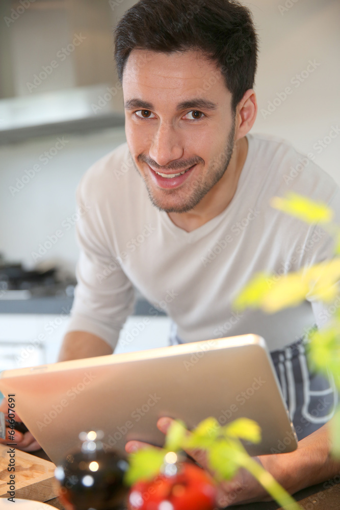 Man in domestic kitchen looking at recipe on tablet Man in domestic kitchen looking at recipe on tablet