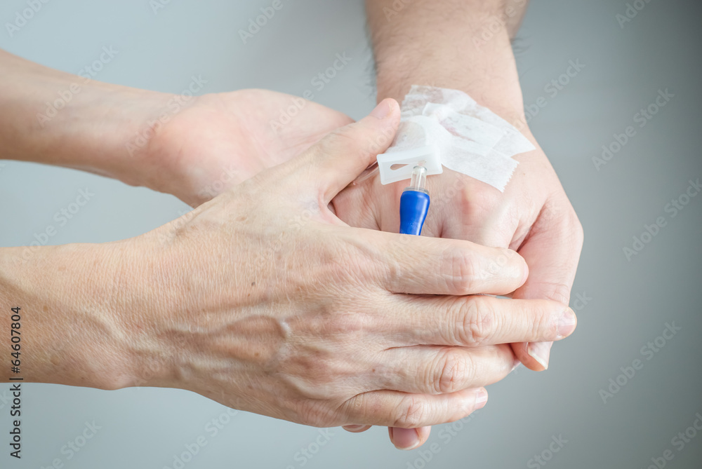 Mom hands holding her son hand with IV infusion device Mom hands holding her son hand with IV infusion device