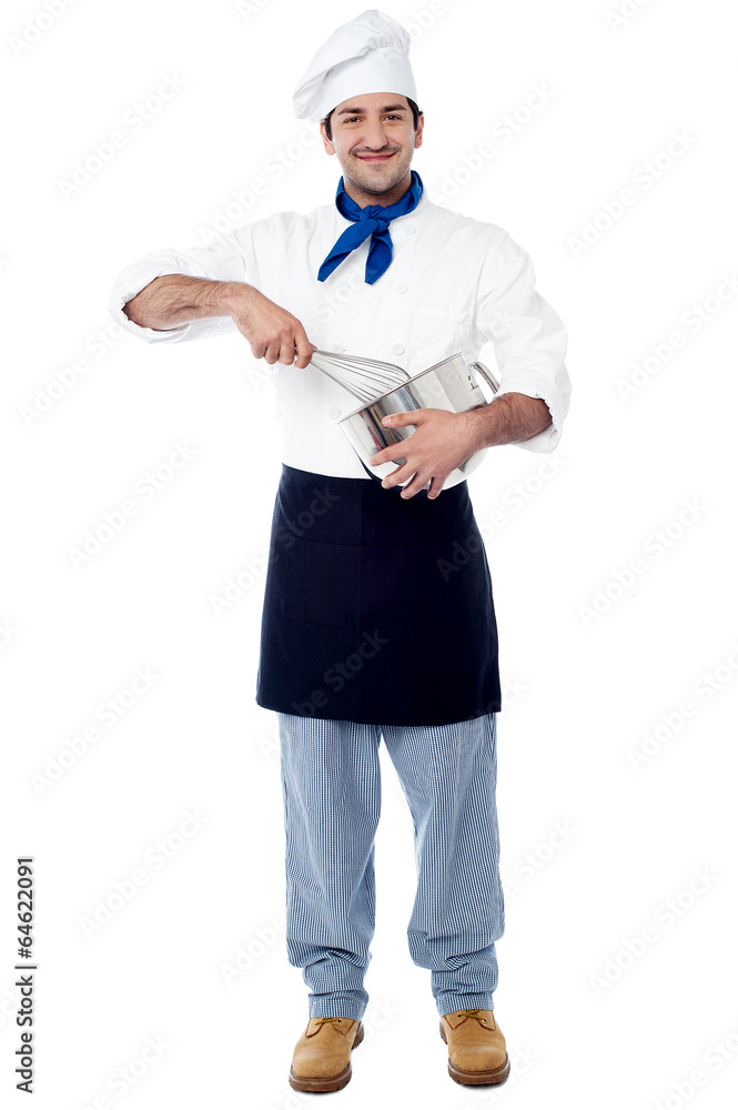 Cheerful chef mixing batter in the kitchen Cheerful chef mixing batter in the kitchen