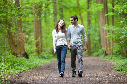 Foto Young couple having a walk in a forest