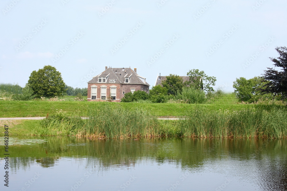 Fototapeta premium Lonely old House, with a body of water in the foreground