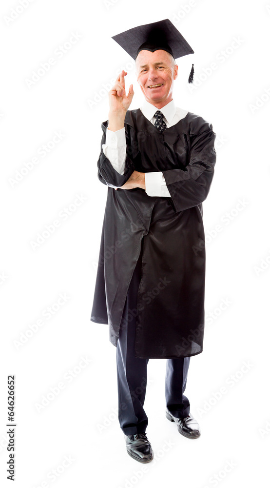 Senior male graduate standing with finger crossed Senior male graduate standing with finger crossed