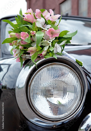 Fototapeta Naklejka Na Ścianę i Meble -  Bouquet for a wedding ceremony lying on old retro car