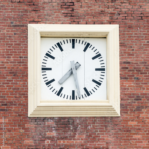 Square clock on a brick wall