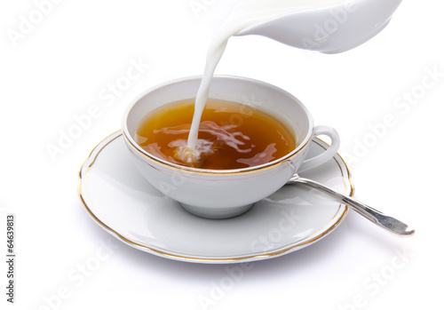 Milk poured into a cup of tea