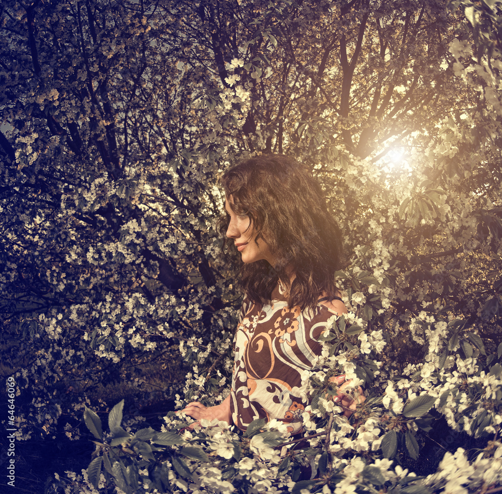 Fotografie young woman at cherry tree branches