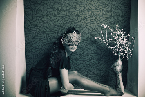 fashion lady in mask sitting at wall hole