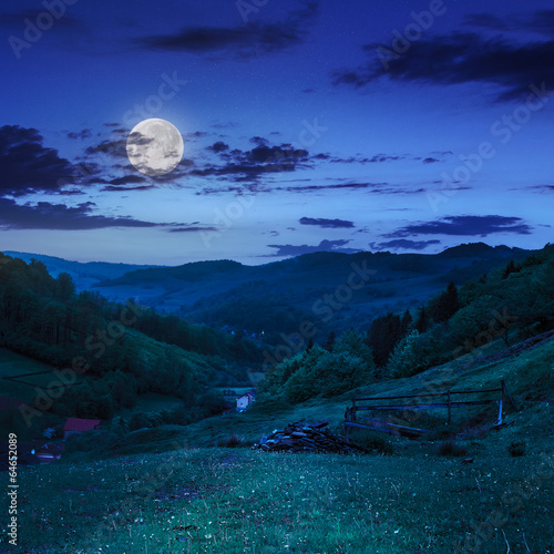 fence in mountains on hillside near village at night
