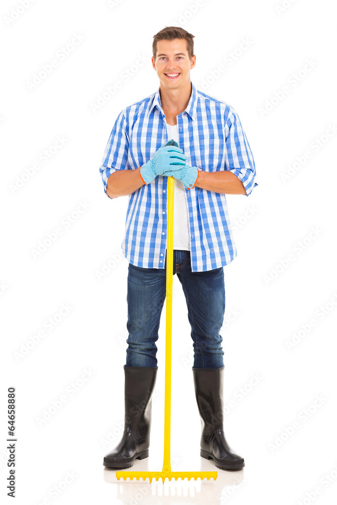 Fototapeta premium young man standing with metal garden rake