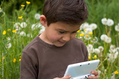 Junge beim Nintendo spielen im Garten 3