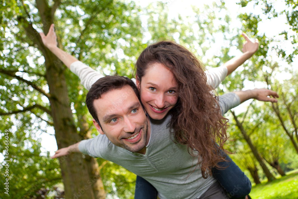 Young happy couple having fun at the park Young happy couple having fun at the park