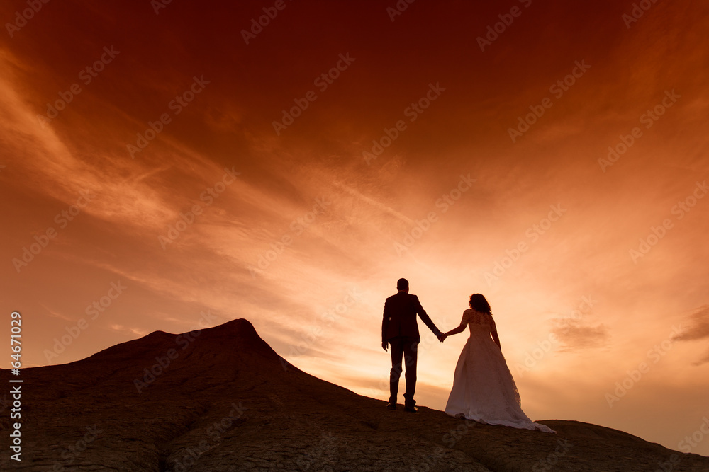 Silhouette of wedding couple with the red sunset