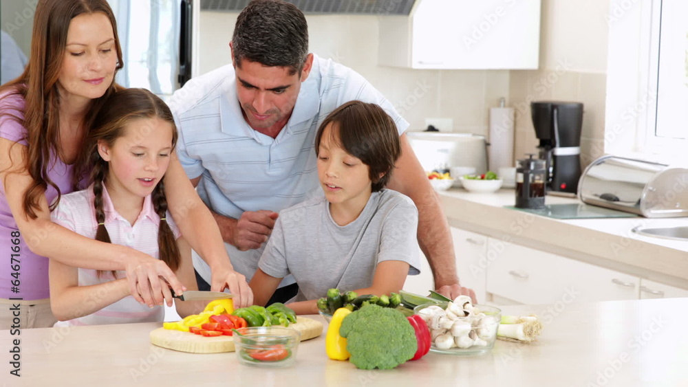 Mother showing her children how to slice vegetables Mother showing her children how to slice vegetables