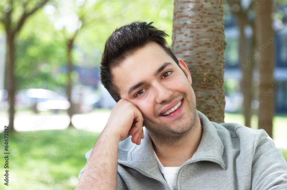 Laughing student in a grey jacket relaxing at the campus