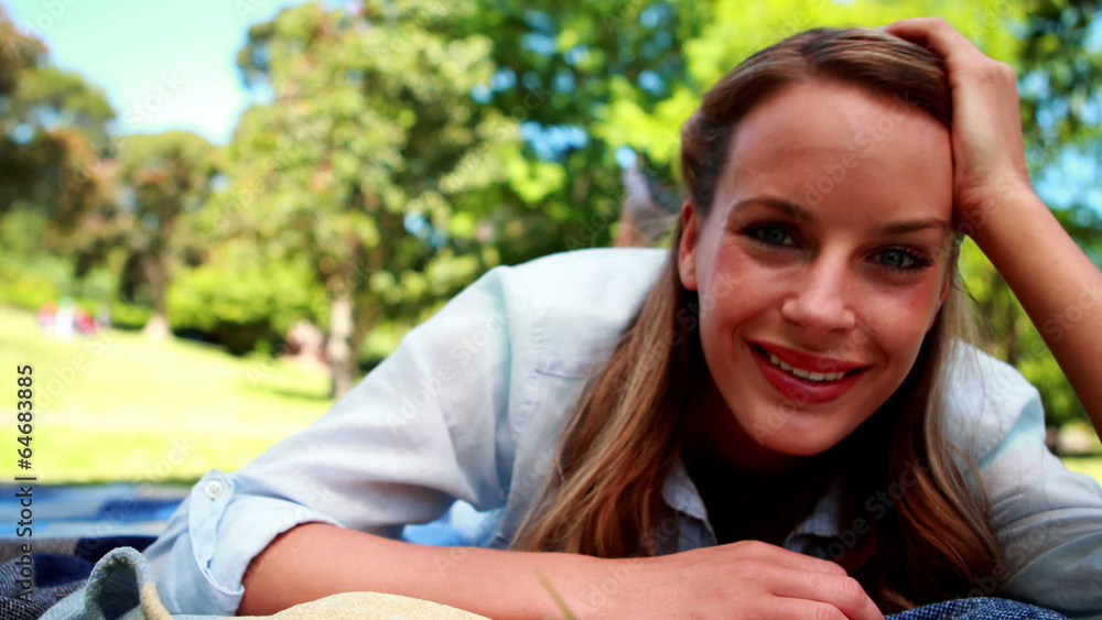 Pretty blonde smiling at the camera in a park Pretty blonde smiling at the camera in a park