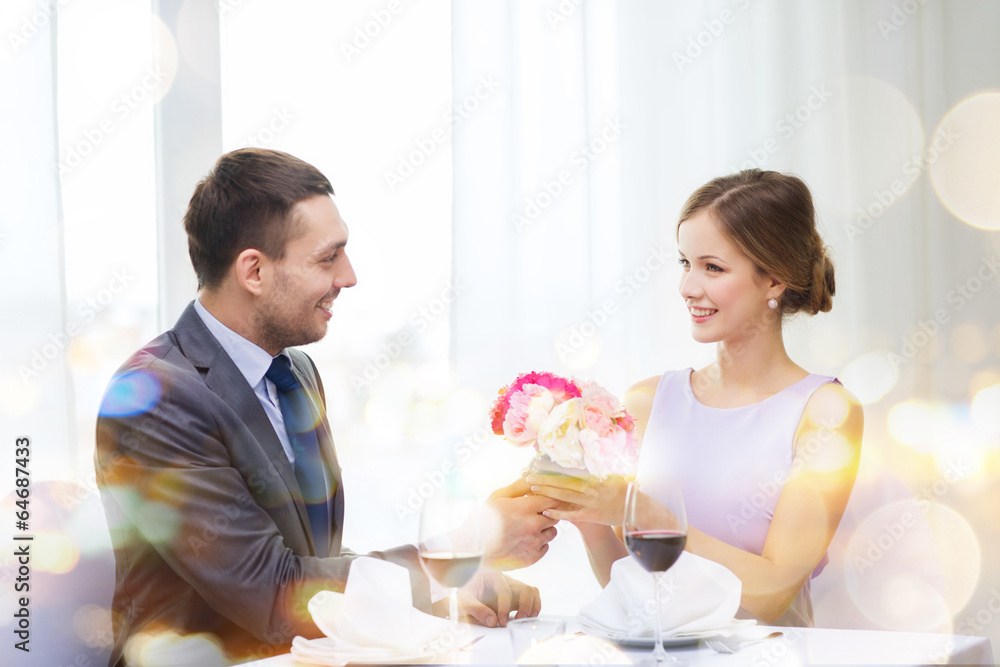 smiling man giving flower bouquet at restaurant smiling man giving flower bouquet at restaurant
