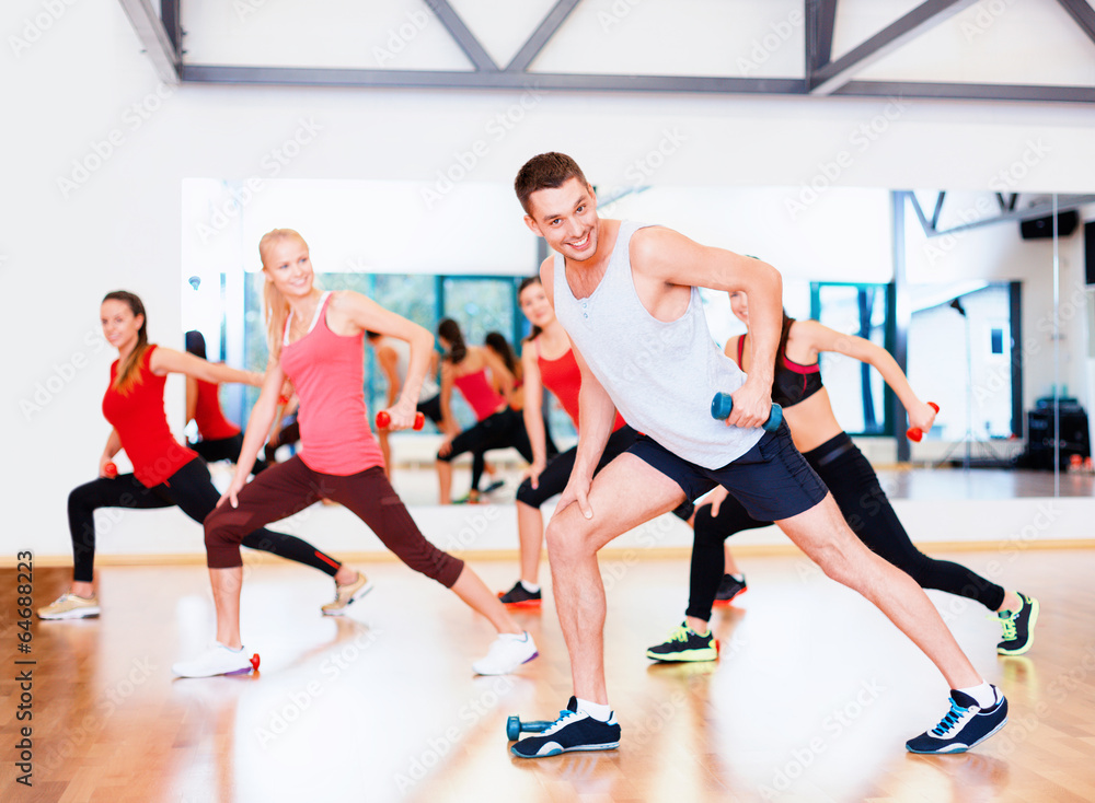 group of smiling people working out with dumbbells group of smiling people working out with dumbbells