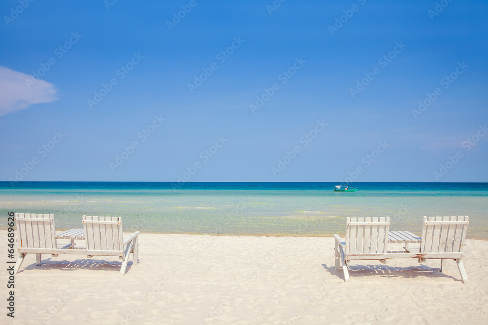 White wooden chairs on white sand beach