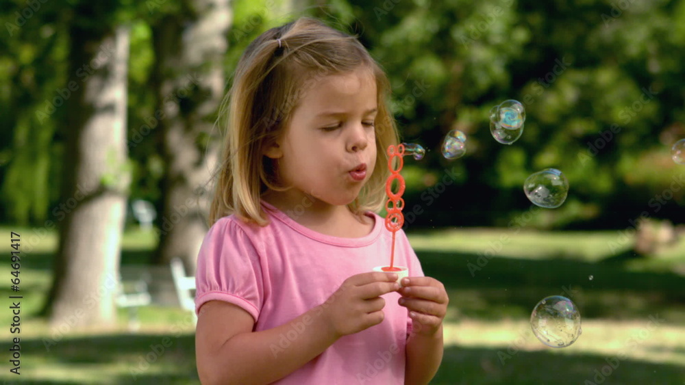 Little girl playing with bubbles in the park Little girl playing with bubbles in the park