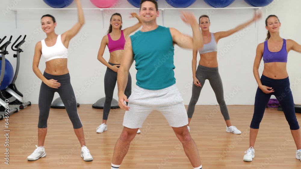 Aerobics class stretching together led by instructor Aerobics class stretching together led by instructor