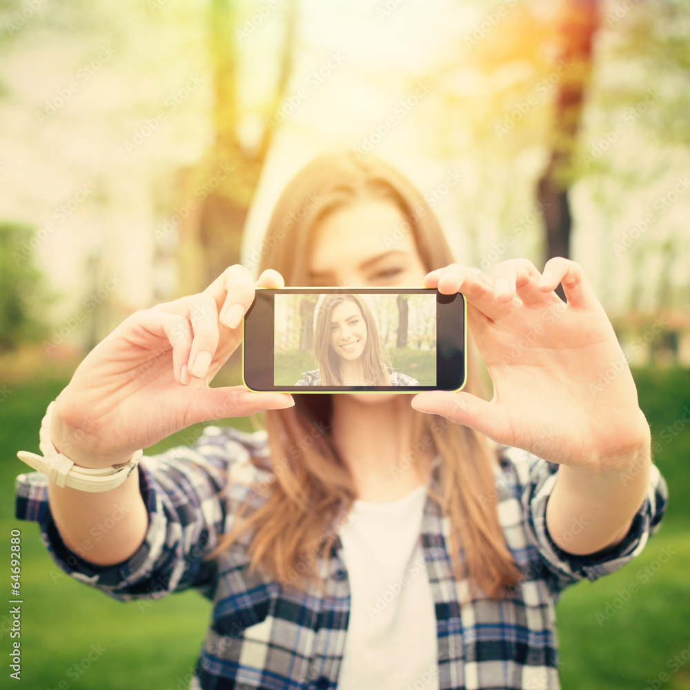 Beautiful young woman taking a selfie