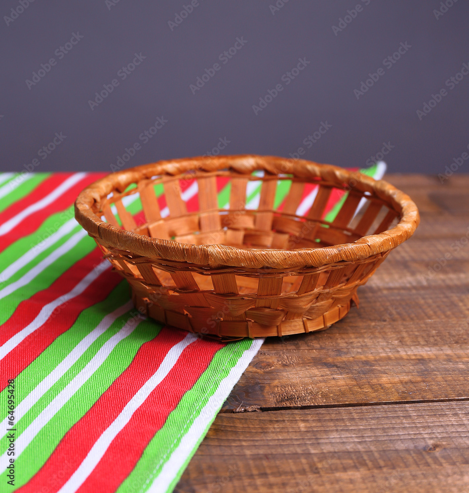 Empty wicker basket on wooden table, on dark background Empty wicker basket on wooden table, on dark background
