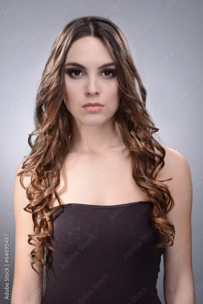 Beautiful young woman with long hair on grey background Beautiful young woman with long hair on grey background