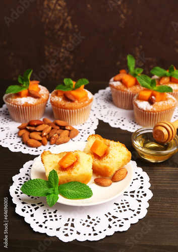 Tasty pumpkin muffins on wooden table