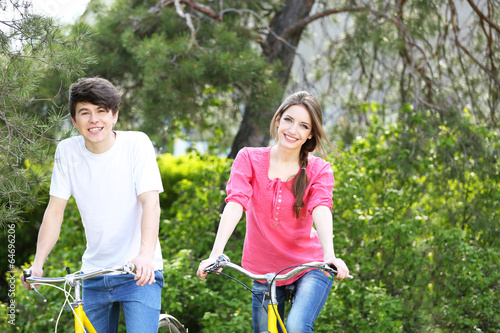 Young couple on bicycles in park