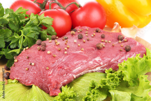Raw beef meat with spices and vegetables close up