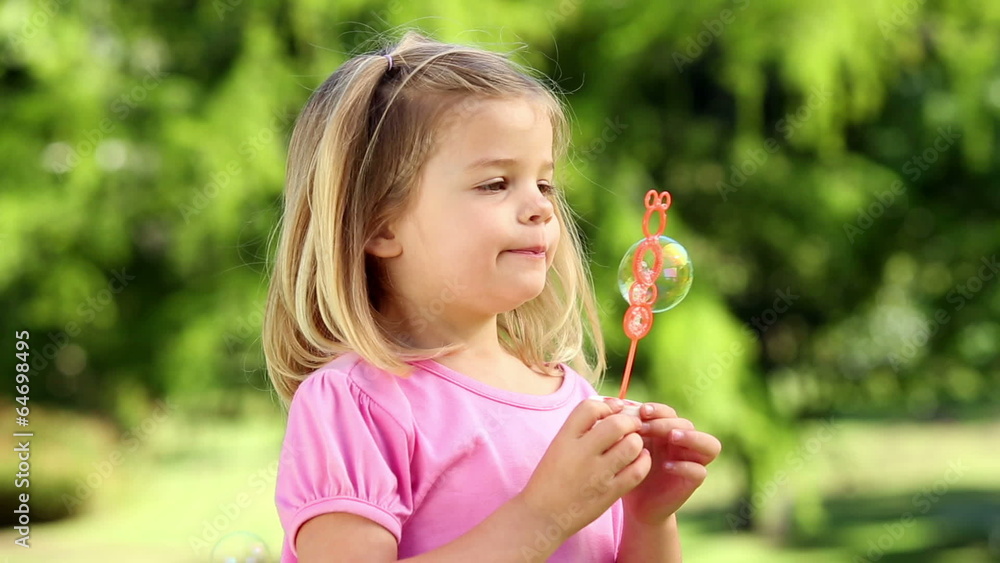 Little girl playing with bubbles in the park Little girl playing with bubbles in the park