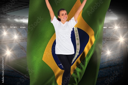 Excited football fan in white cheering holding brasil flag