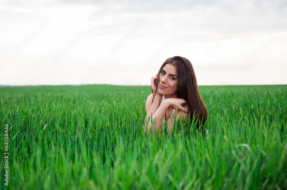 Young woman relaxing and smiling in fresh green fiel Young woman relaxing and smiling in fresh green fiel