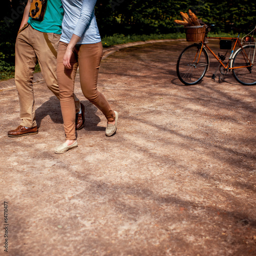 couple walking and hugging in the park with bicycle on the backg © rh2010