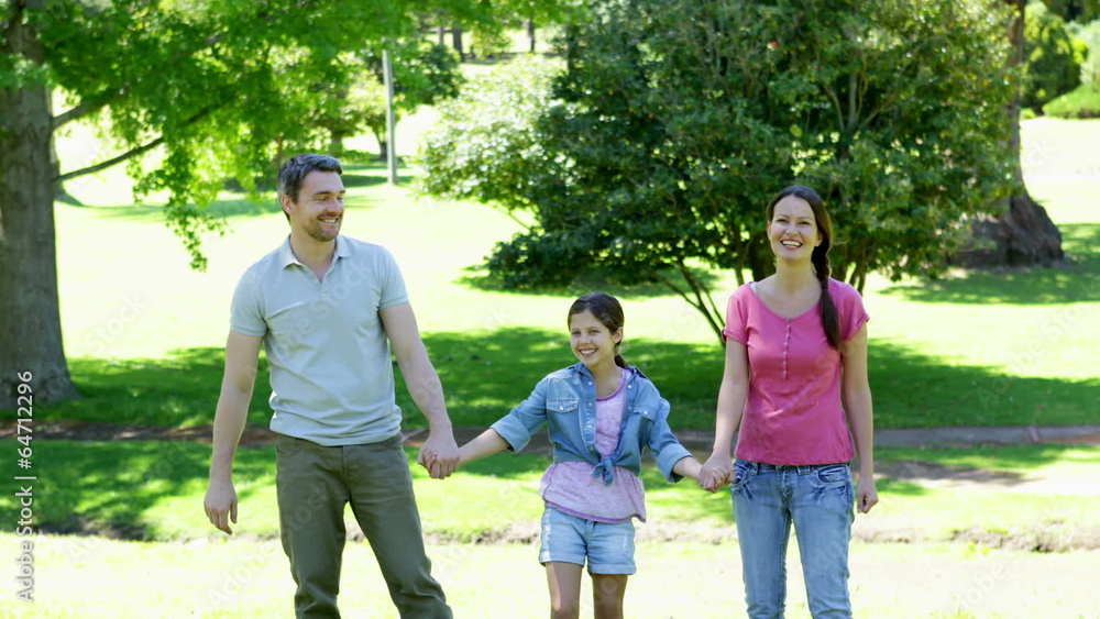 Happy parents and daughter jumping in the park Happy parents and daughter jumping in the park