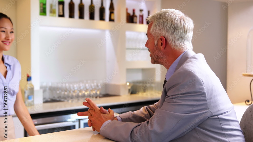 Businessman ordering a drink from barmaid Businessman ordering a drink from barmaid