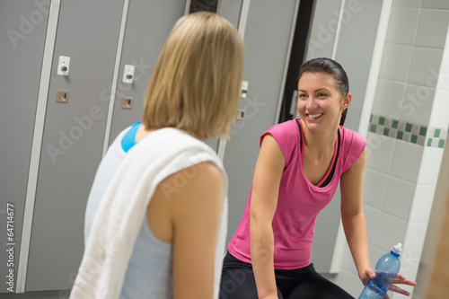 Smiling woman talking with friend changing room
