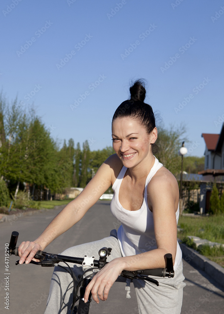Obraz premium Happy young woman on bike.