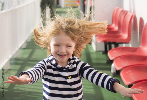 Fotografija Little blonde girl running with windswept hair