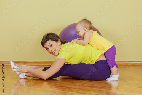 Mother does physical exercises with her daughter at home